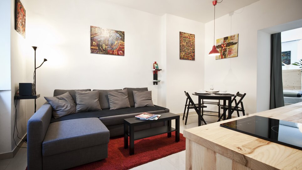 Appartamento luminoso e moderno con divano, tavolo da pranzo e opere d'arte. | © Grocholl