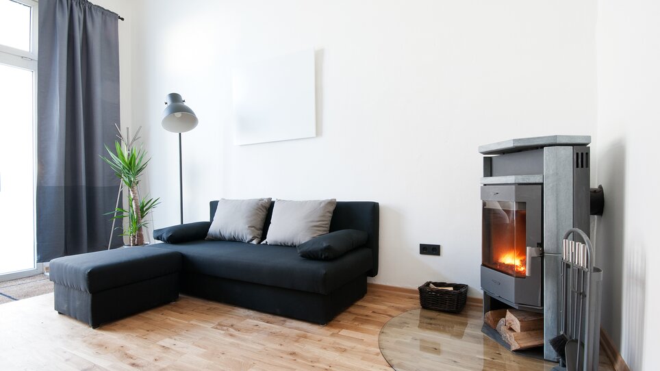 Vista di un soggiorno moderno con divano e camino. | © Grocholl