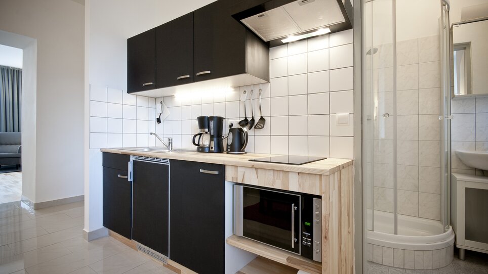 Cucina negli appartamenti Grocholl con microonde e doccia. | © Grocholl