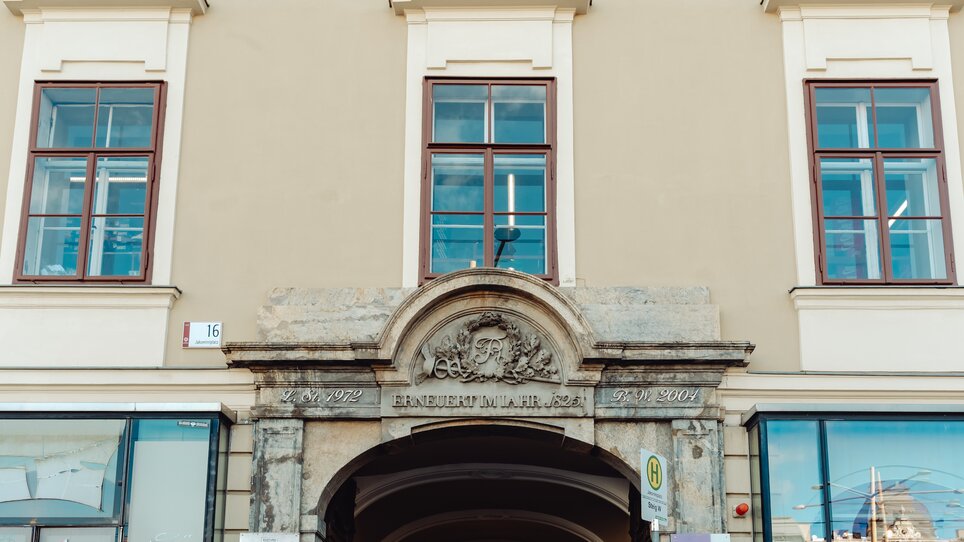 Detailaufnahme eines historischen Gebäudes am Jakominiplatz Graz mit Fenster und Inschrift. | © Lilians Apartments