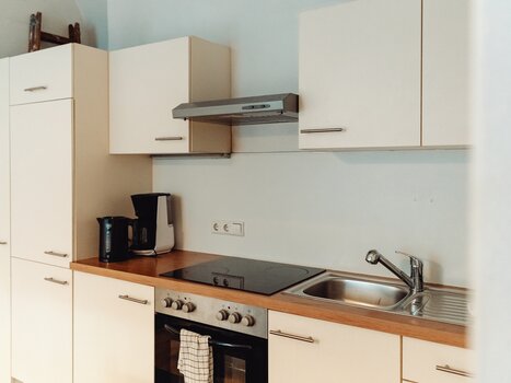 Küchenansicht mit Kochfeld, Spüle und modernen Geräten. | © Lilians Apartments