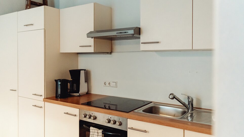 Küchenansicht mit Kochfeld, Spüle und modernen Geräten. | © Lilians Apartments