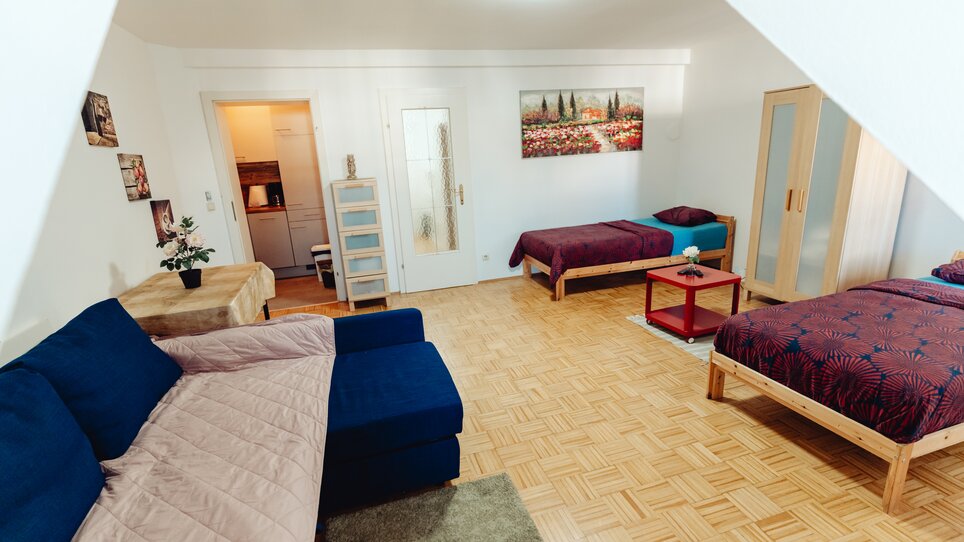 Helles Zimmer mit Schlafplätzen und Sitzgelegenheit. | © Lilians Apartments