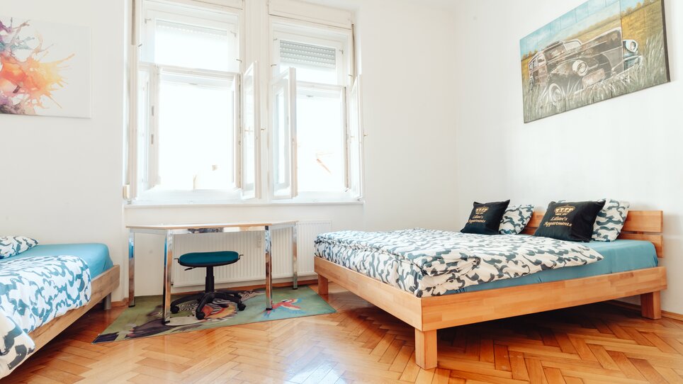 Gemütliches Zimmer mit zwei Betten, Schreibtisch und Tageslicht. | © Lilians Apartments