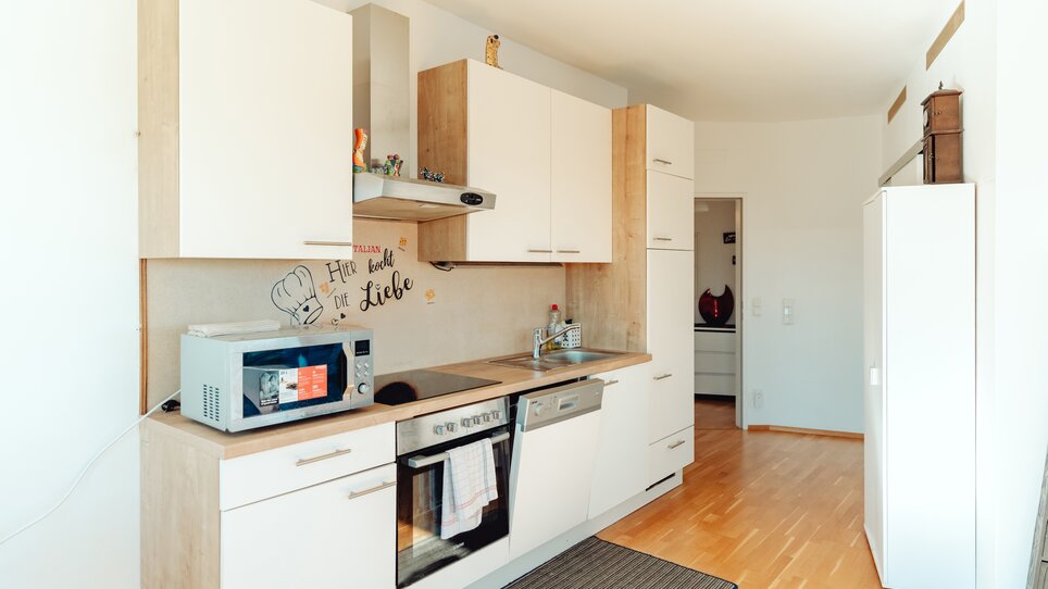 Eine helle, moderne Küche mit Holz-Elementen und Küchenutensilien. | © Lilians Apartments