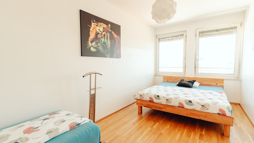 Gemütliches Schlafzimmer mit zwei Betten und einem Tigerbild. | © Lilians Apartments