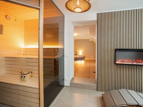 View of a modern sauna with glass door. | © HERO HOMES Design Apartments