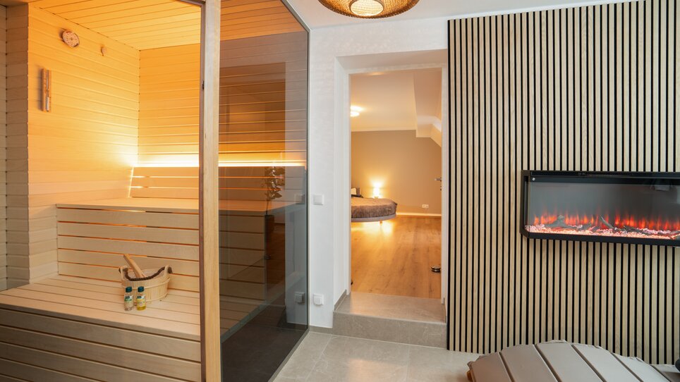 Einblick in eine moderne Sauna mit gläserner Tür. | © HERO HOMES Design Apartments