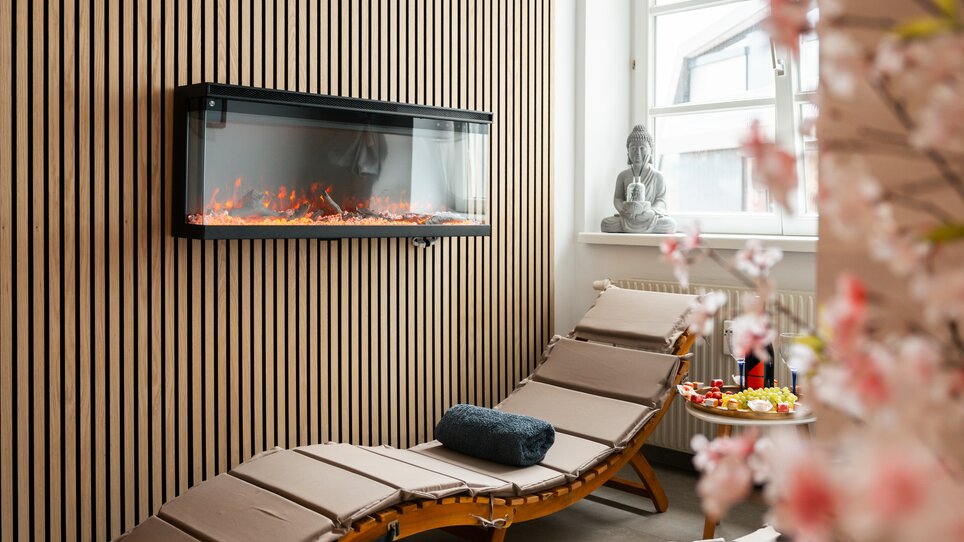 Modernes Spa mit Liege, elektrischer Feuerstelle und Buddha-Statue. | © HERO HOMES Design Apartments