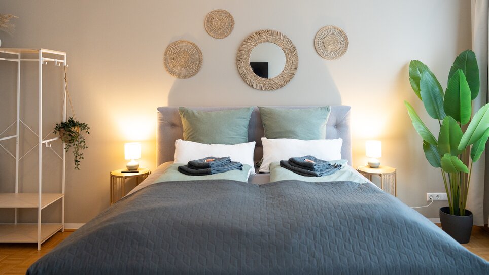 Gemütliches Schlafzimmer mit neutralen Farben und Pflanzen. | © HERO HOMES Design Apartments