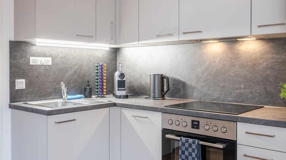 Eine moderne Küche mit viel Stauraum und stilvoller Ausstattung. | © HERO HOMES Design Apartments