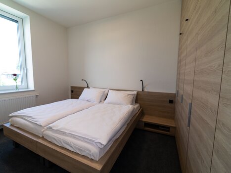 Bright bedroom with a double bed and window. | © Tomo-Tec Immo GmbH