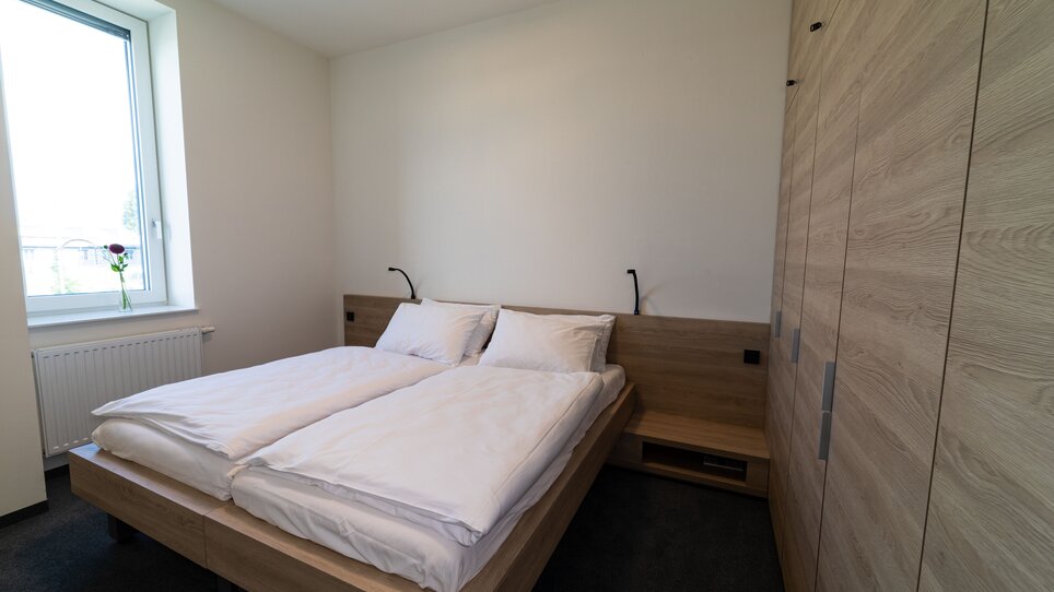 Camera luminosa con letto matrimoniale e finestra. | © Tomo-Tec Immo GmbH