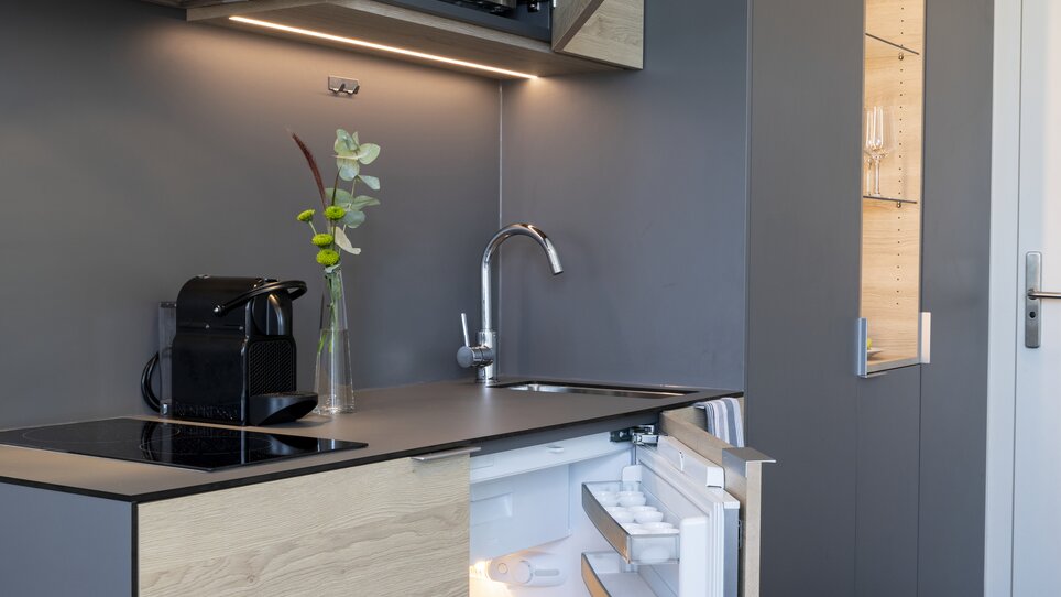 Vista di una cucina in un hotel appartamento con frigorifero e microonde. | © Tomo-Tec Immo GmbH