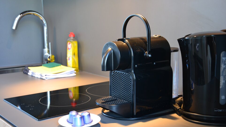 Una macchina Nespresso e capsule di caffè su un piano cucina. | © Tomo-Tec Immo GmbH