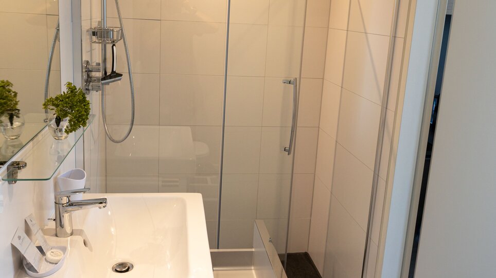 Bagno con doccia e lavabo moderno nel TT-Rooms Apartment-Hotel. | © Tomo-Tec Immo GmbH