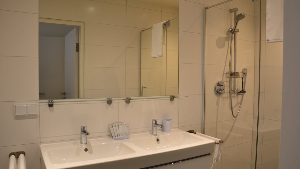 Bagno con lavabo doppio e doccia. | © Tomo-Tec Immo GmbH