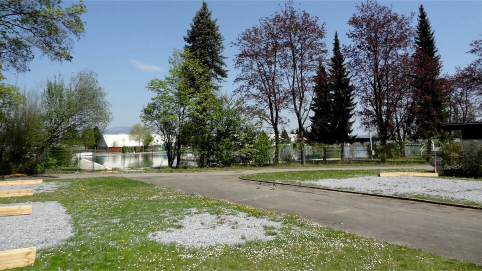 View of the motorhome parking area with trees and water. | © Alfred Chyba