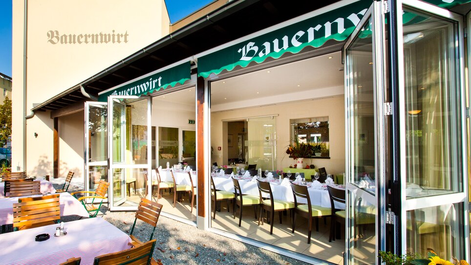 Eine Ansicht des Restaurants Bauernwirt in Graz mit Außenbereich und gedeckten Tischen. | © Bauernwirt