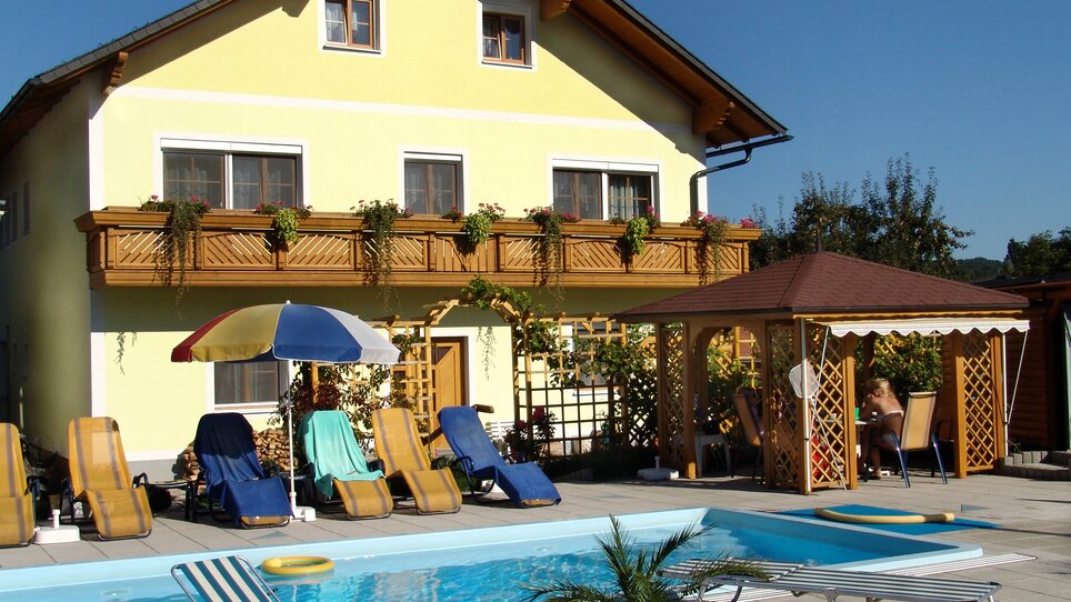 Außenansicht der Pension Scherwirt mit Pool und Liegen. | © Scherwirt