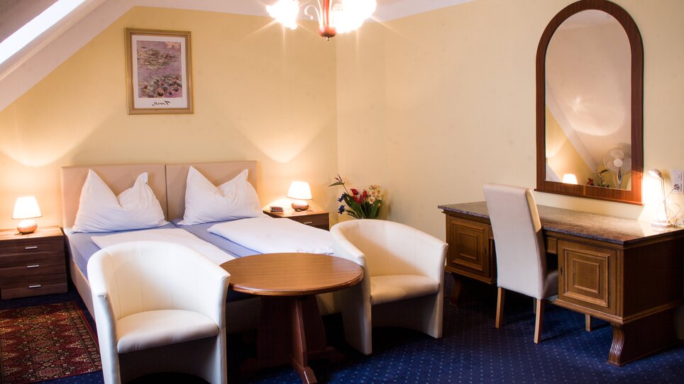 Una camera confortevole con letto matrimoniale, tavolo e sedie all'Hotel Alter Telegraf. | © Hotel Alter Telegraf