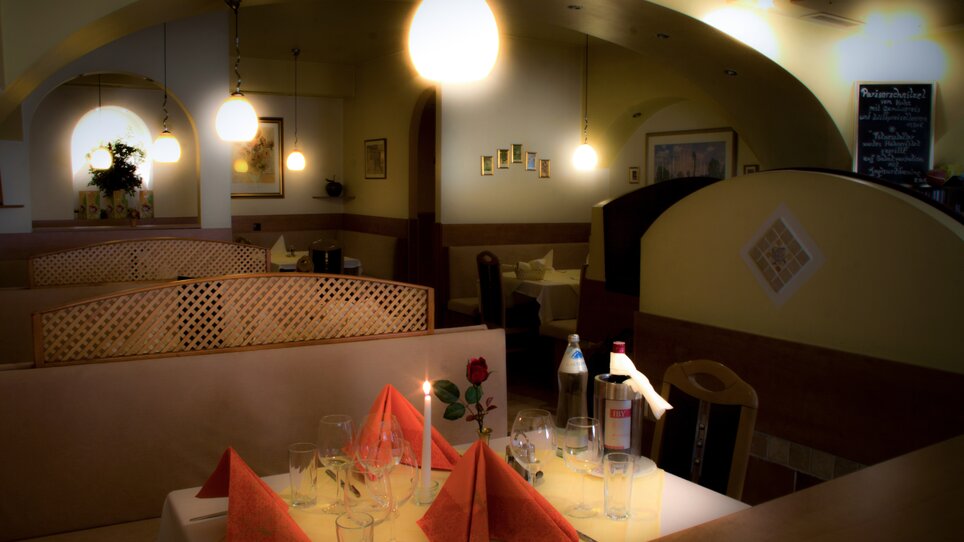 Un tavolo ben impostato in un ristorante elegante con decorazioni rosse. | © Hotel Alter Telegraf