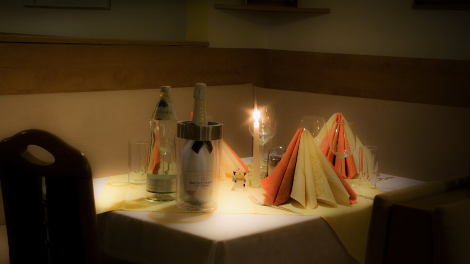 Un tavolo imbandito con luce di candela, bottiglie e tovaglioli. | © Hotel Alter Telegraf