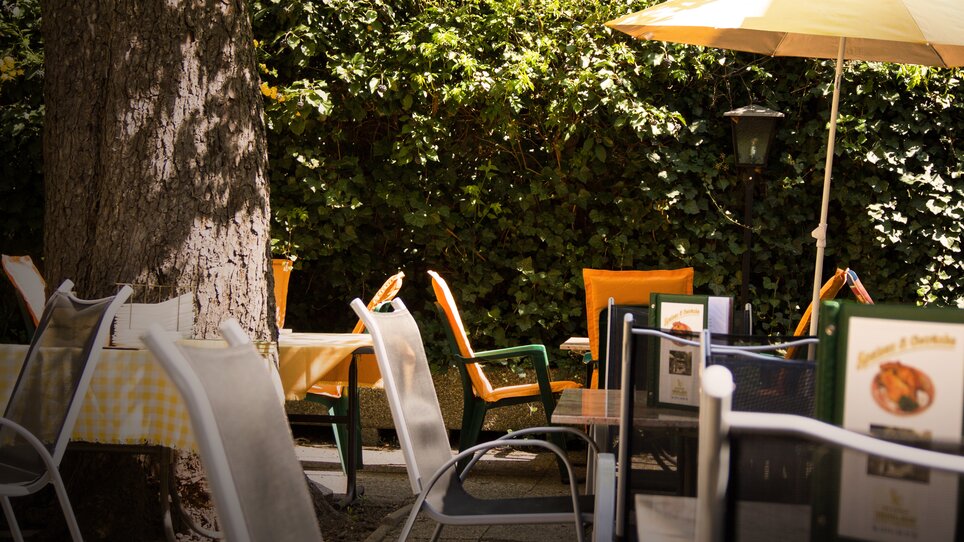Terrazza all'aperto con tavoli e sedie, circondata dal verde. | © Hotel Alter Telegraf