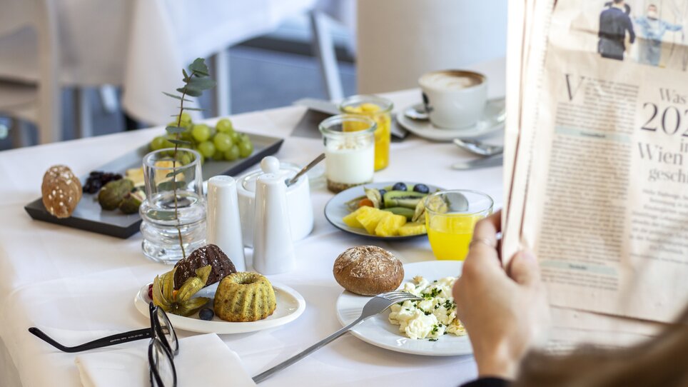 Blick auf ein Frühstück mit Kaffee, Früchten und Brötchen im Augarten Art Hotel. | © Augarten Art Hotel