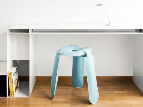 Ein stilvoller blauer Hocker vor einem eleganten Schreibtisch. | © Augarten Art Hotel