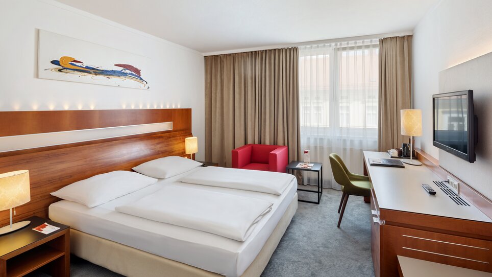 Ein Zimmer im Austria Trend Hotel Europa in Graz mit zwei Betten, Schreibtisch und Fernseher. | © Austria Trend Hotel Europa