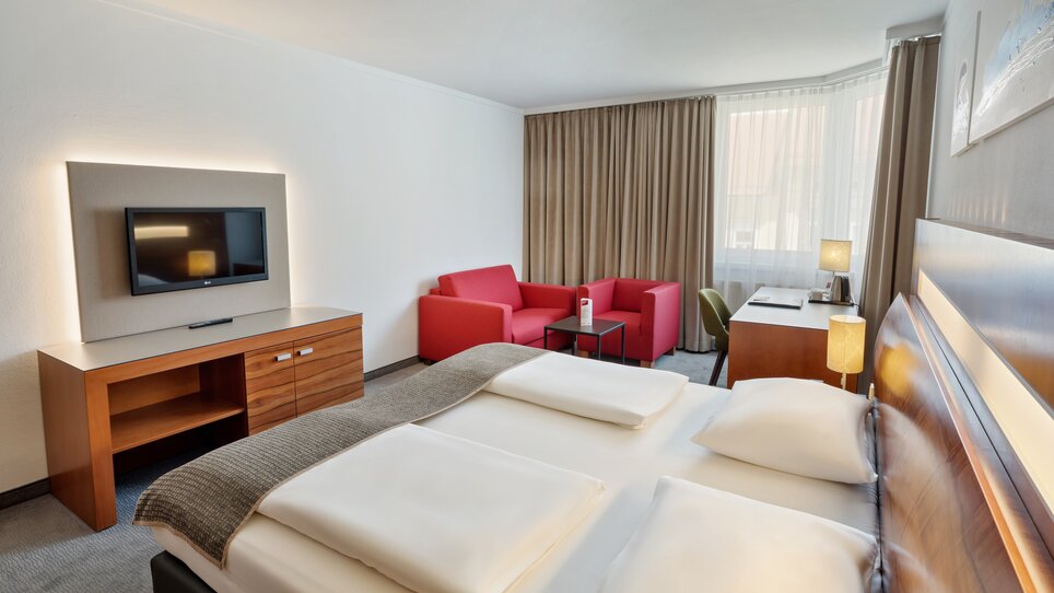 Ein Zimmer im Austria Trend Hotel Europa mit einem Doppelbett, Fernseher und Sitzecke. | © Austria Trend Hotel Europa