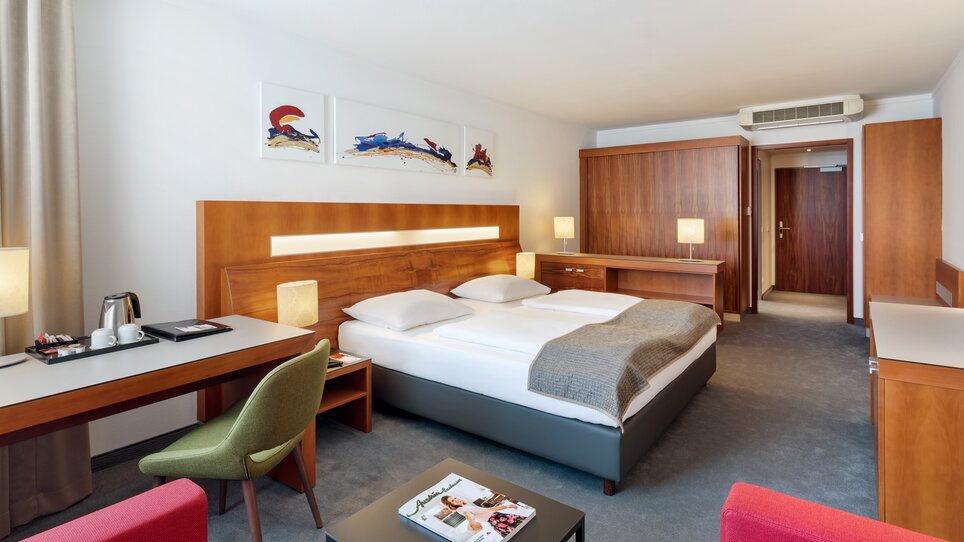 Einblick in ein Hotelzimmer mit Doppelbett und Sitzecke im Austria Trend Hotel Europa. | © Austria Trend Hotel Europa