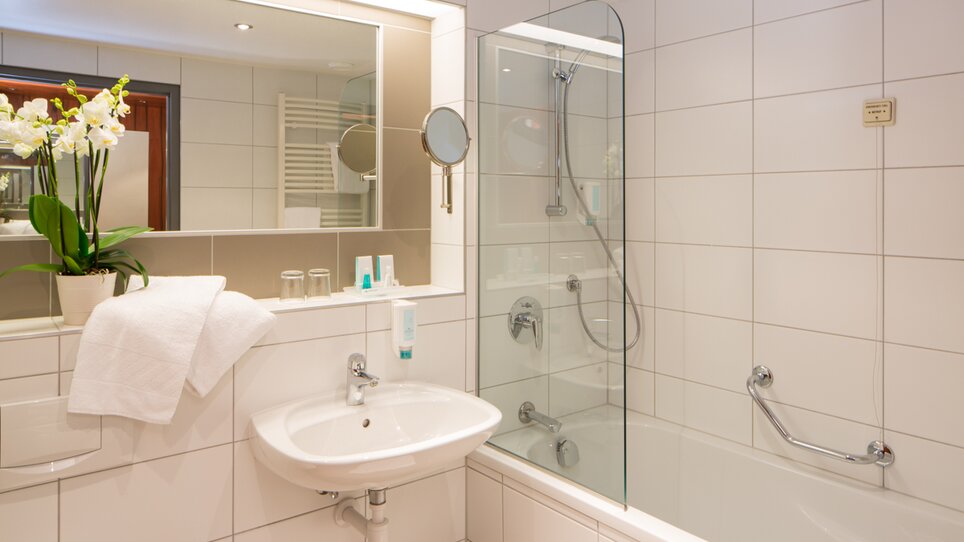 Modernes Badezimmer mit Dusche, Badewanne und Pflanzenarrangement. | © Austria Trend Hotel Europa Graz