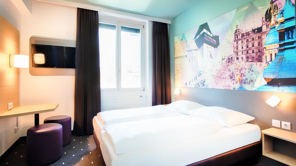 Ein gemütliches Hotelzimmer im B&B Hotel Graz-Hbf mit zwei Betten und modernen Möbeln. | © B&B Hotels 2023