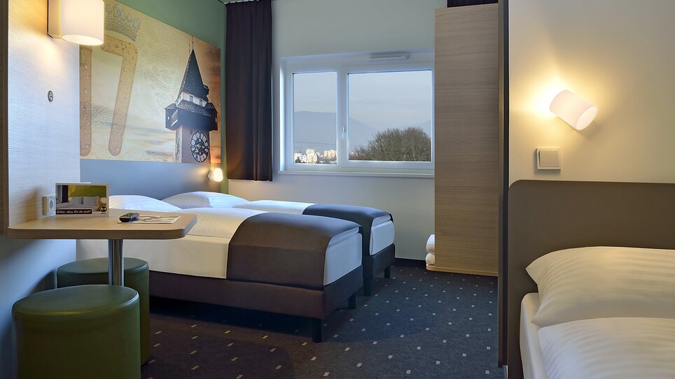 Camera doppia con letto supplementare e vista sulla città. | © B&B Graz City Süd