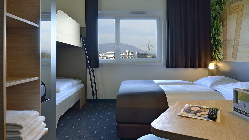 Vista di una camera con letto matrimoniale e un letto a castello. | © B&B Graz City Süd