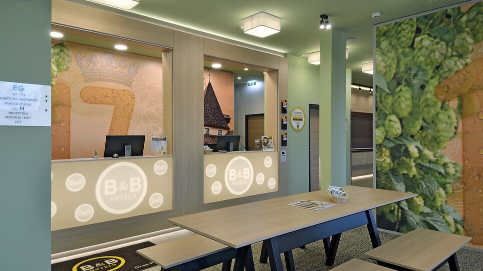 La reception dell'Hotel B&B Graz City-Süd con bancone e area salotto. | © B&B Hotel Graz City Süd