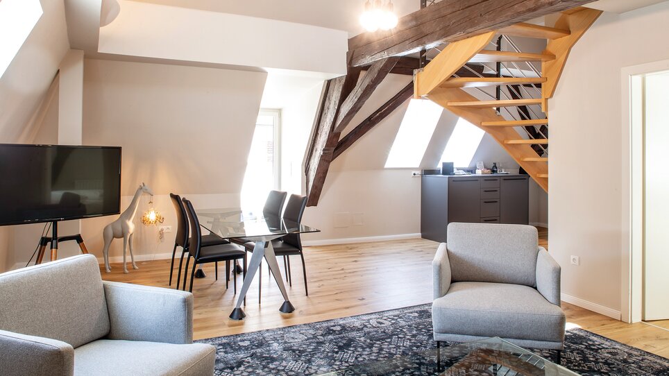 Gemütliches Wohn- und Esszimmer mit Treppe und Fenster. | © Robert Illemann