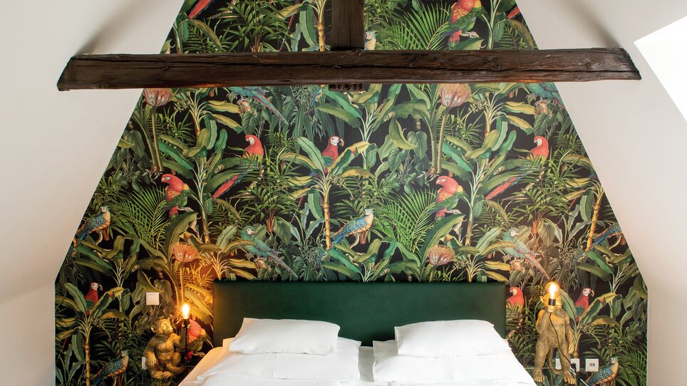 Schlafzimmer mit exotischem Wanddesign und Pflanzenmotiven. | © Robert Illemann