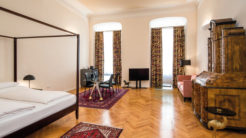 Ein geräumiges Schlafzimmer mit einer Sitzecke und großen Fenstern. | © Robert Illemann