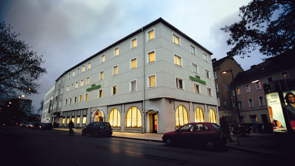 Exterior view of Hotel Feichtinger with illuminated windows. | © Hotel Feichtinger