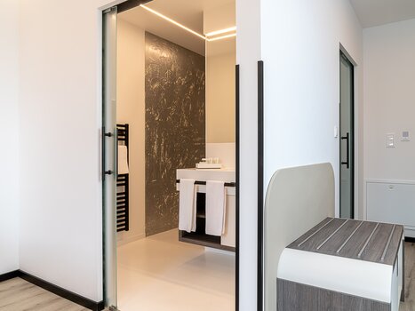 View into a modern bathroom featuring a sink and towel rack. | © Chrizz Rooms