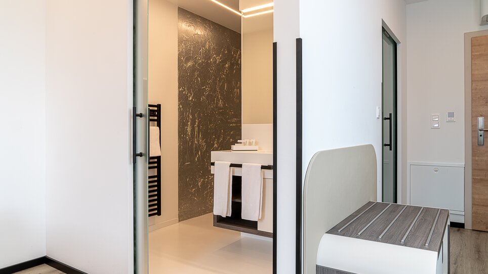 Vista di un bagno moderno con lavandino e portasalviette. | © Chrizz Rooms