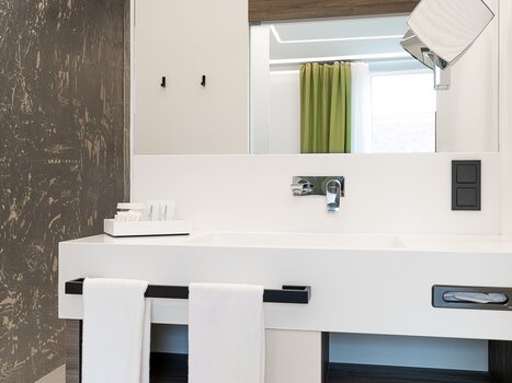Bright bathroom with sink, mirror, and towels. | © Chrizz Rooms