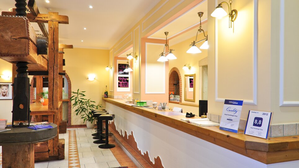 Colorful hotel reception with chairs and plants. | © Hotel Feichtinger