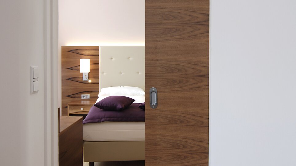 A view of a bedroom through an open door. | © Hotel Feichtinger