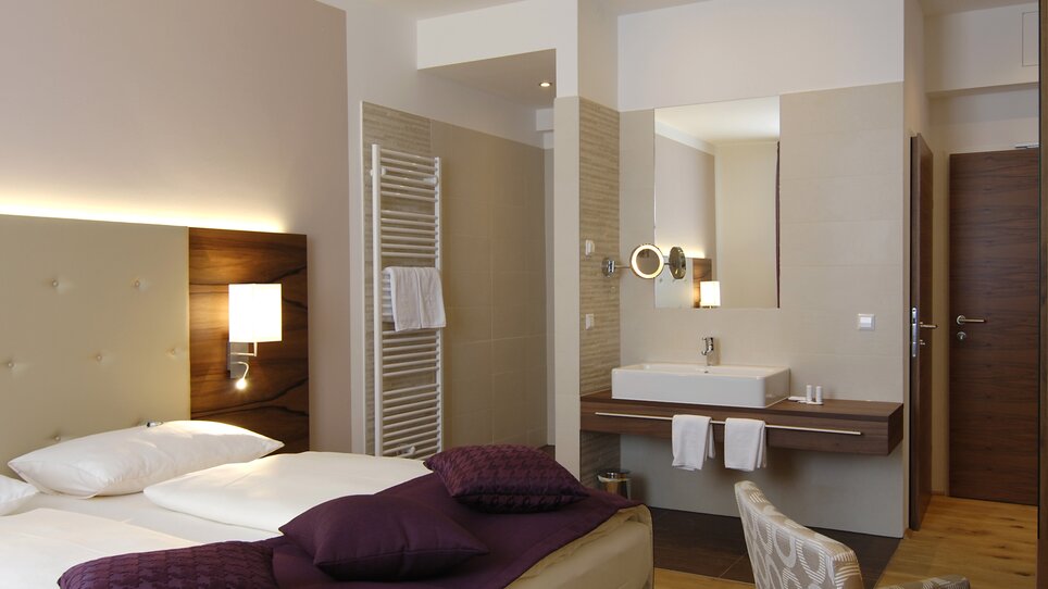 View of a hotel room with double bed and sink. | © Hotel Feichtinger
