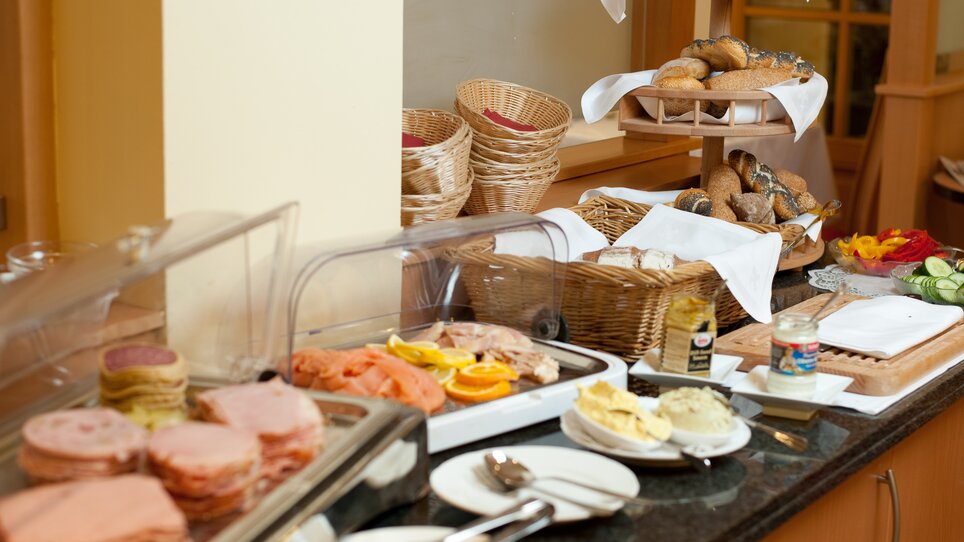 Diverse breakfast buffet with cold cuts, rolls, and vegetables. | © Hotel Feichtinger