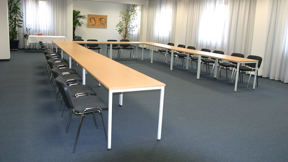 A large meeting room with tables and chairs. | © Hotel Feichtinger